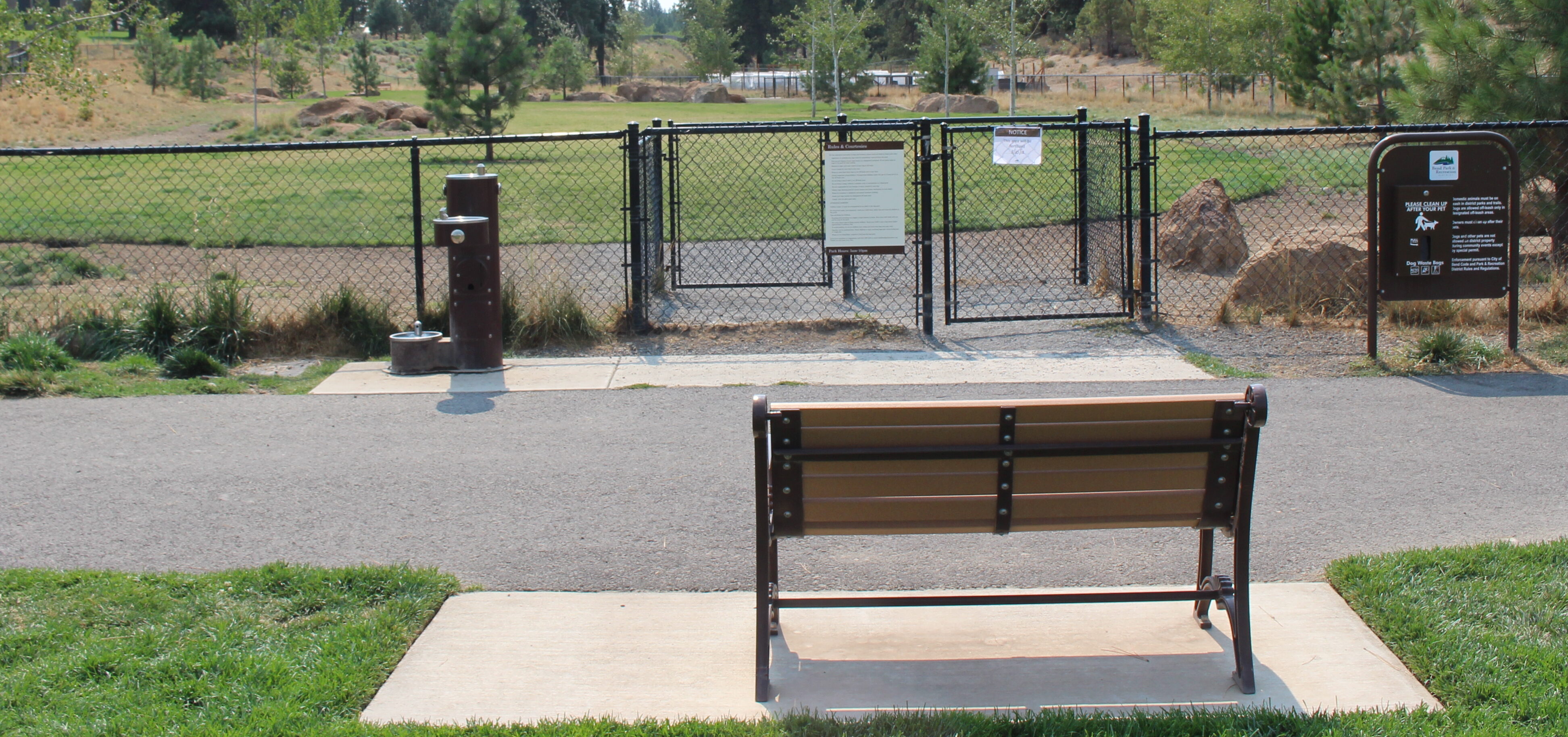 a bench outside the dog park at discovery park
