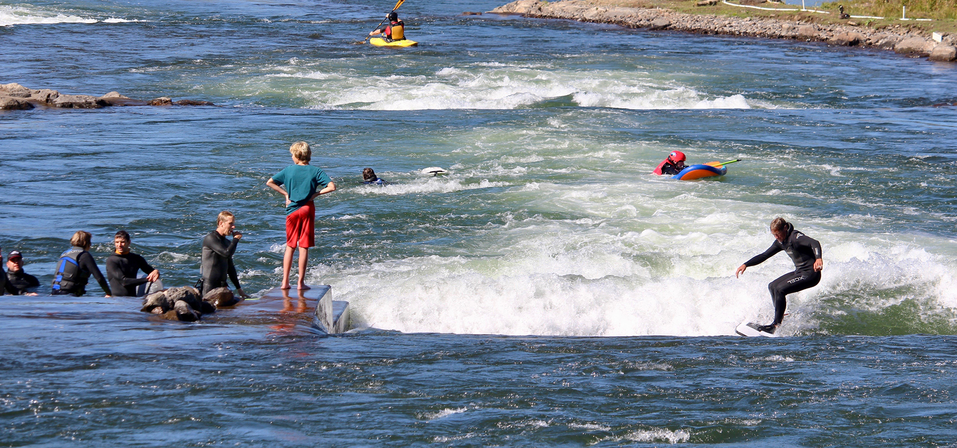 Surfers on the greenwave at Bend Whitewater Park.