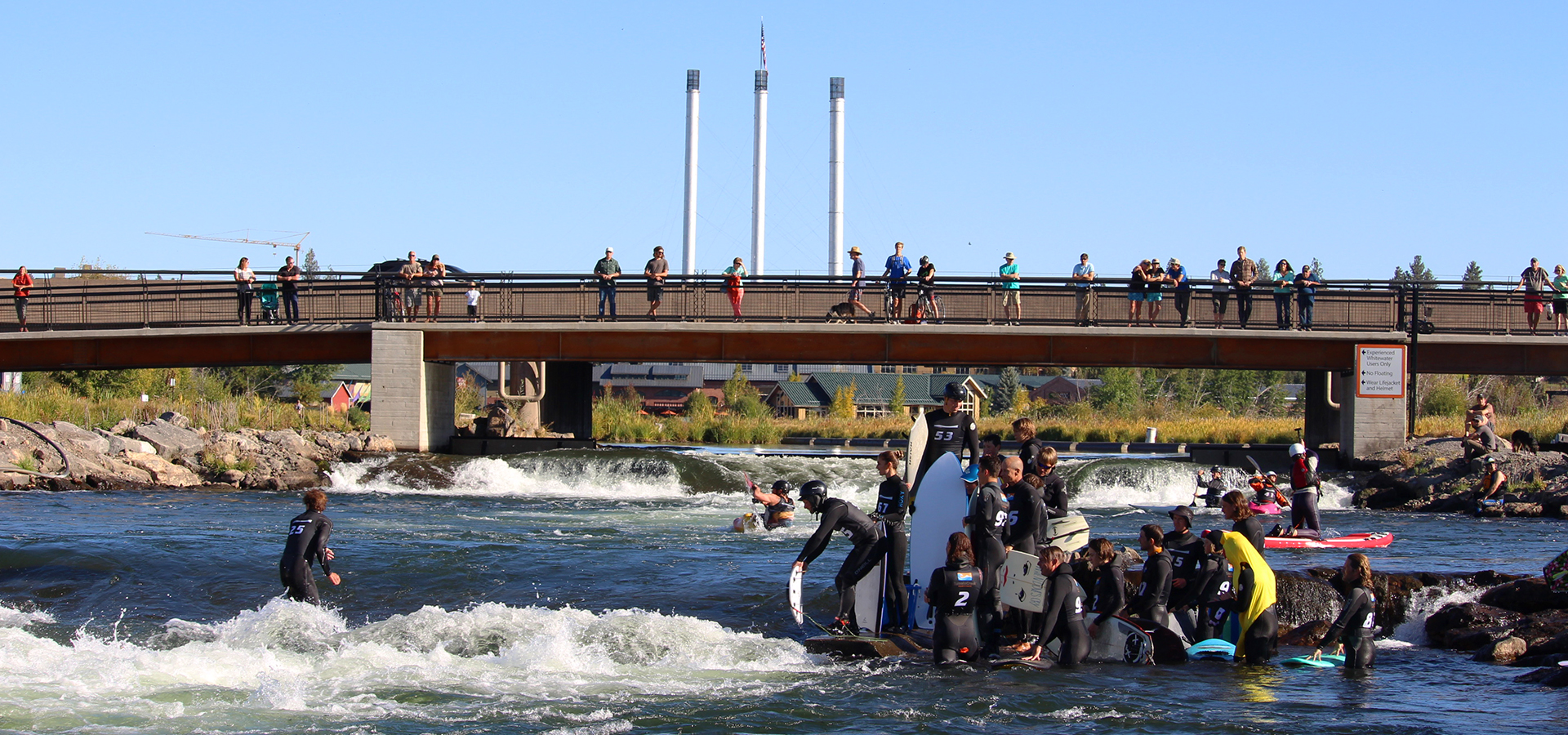 Surfers and floaters at the bend whitewater park.