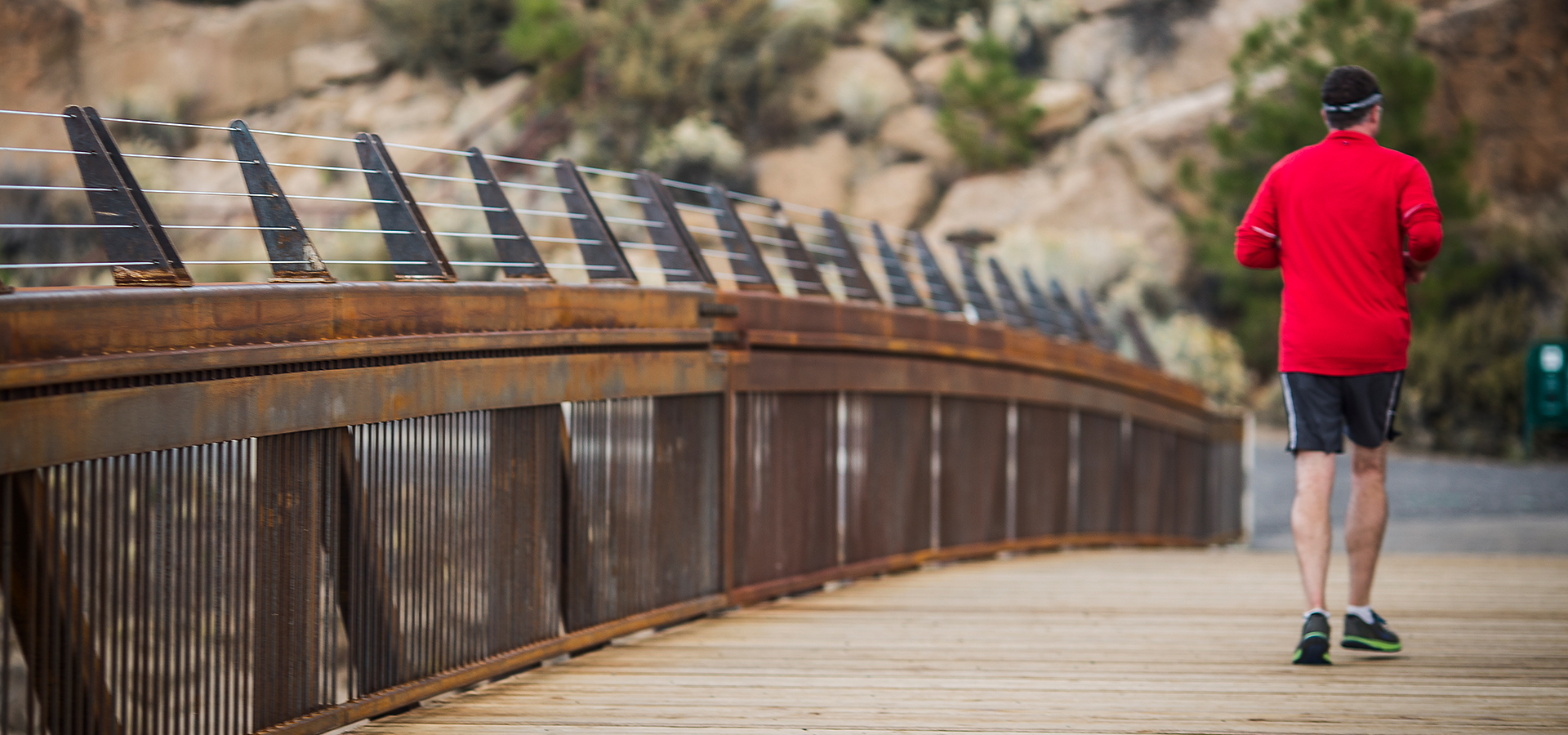 A man running on the pedestrian bridge at Farewell Bend park.