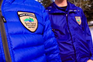 Park stewards badges on jackets of two park stewards.