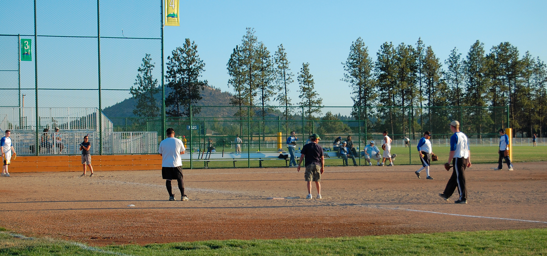 Men playing softball at Pine Nursery Park.