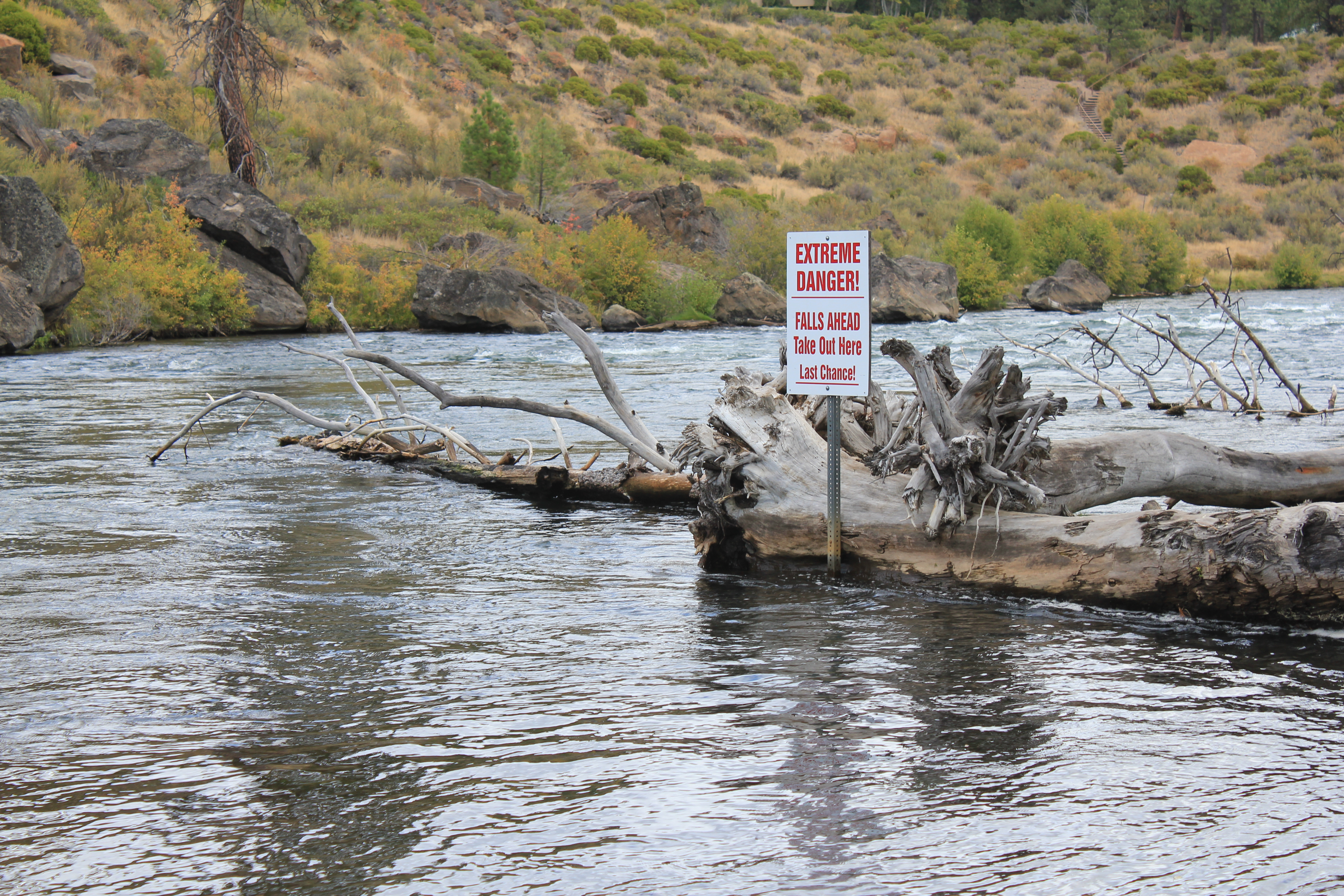 warning sign in the river for rapids at river rim