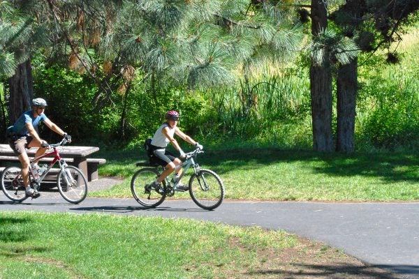 Two adults riding bikes on a path at Sawyer Park.