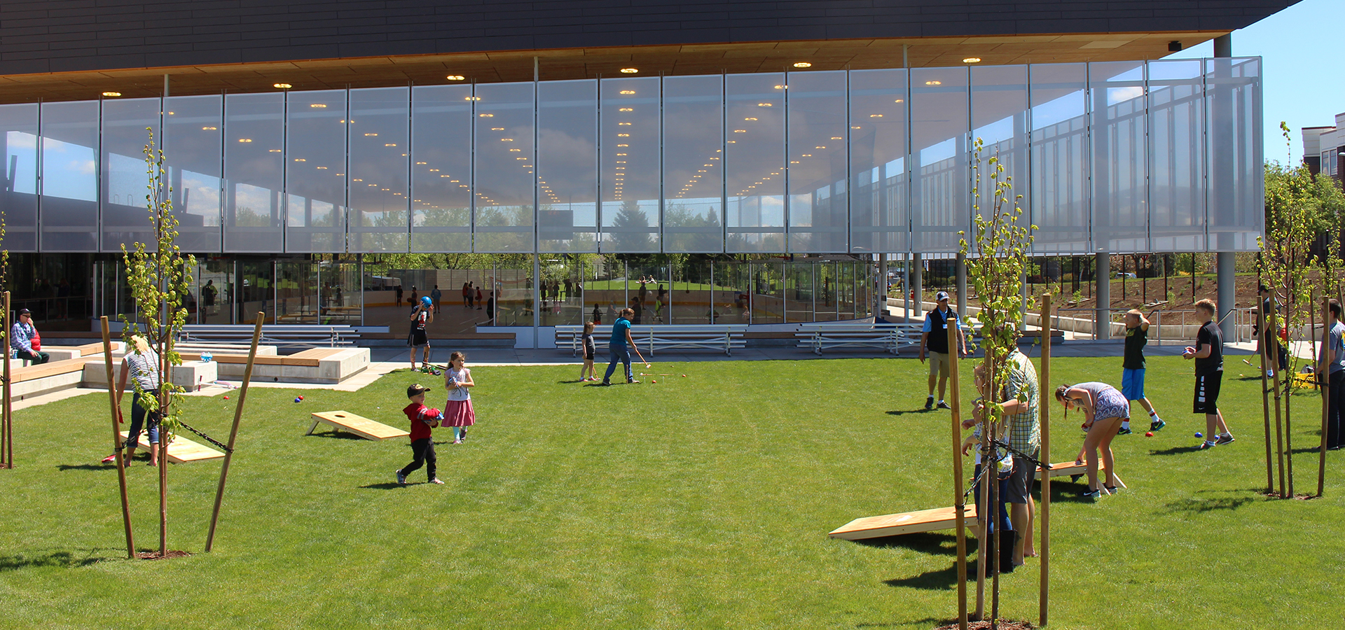 Families playing cornhole outside the pavilion.