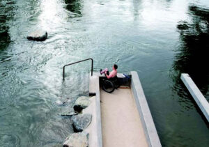 Image of wheelchair patron stagining at the edge of the dry ramp at Miller's Landing