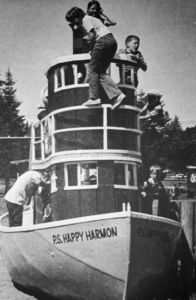 black and white photo of the tugboat playground structure with 5 children climbing and playing