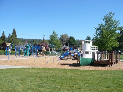 Harmon Park and playground featuring a boat play structure, swings and other play structures