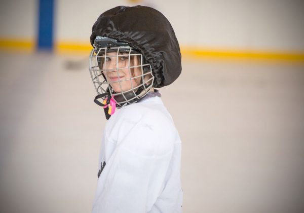 A youth hockey player posing for a picture.