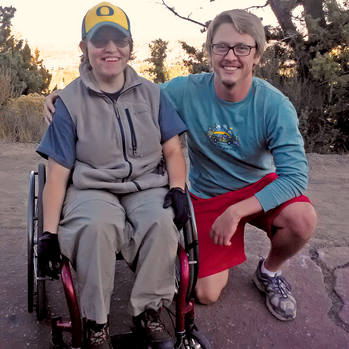 Two people posing for a picture - one is in a wheelchair.