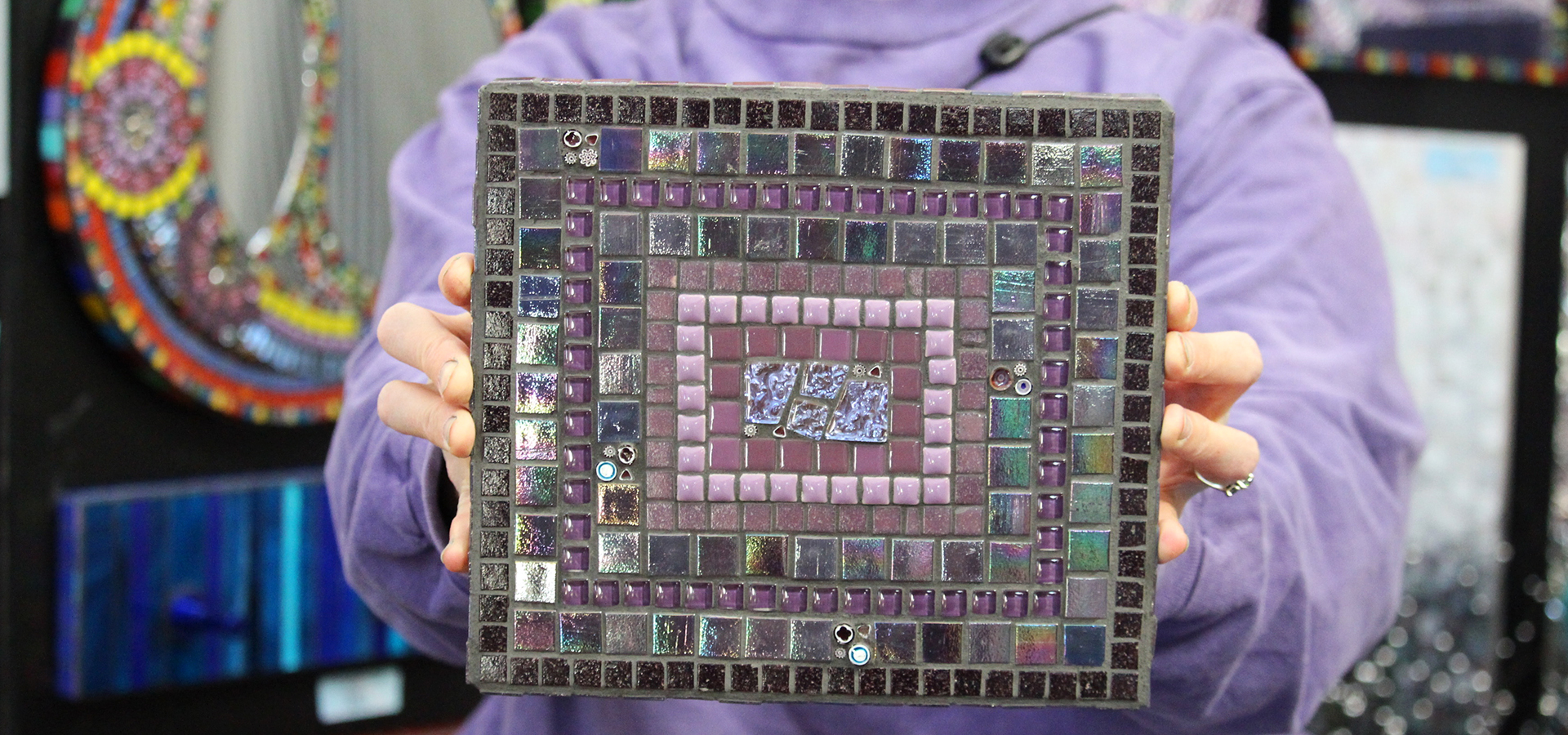 Someone showing off their mosaic after an art class.