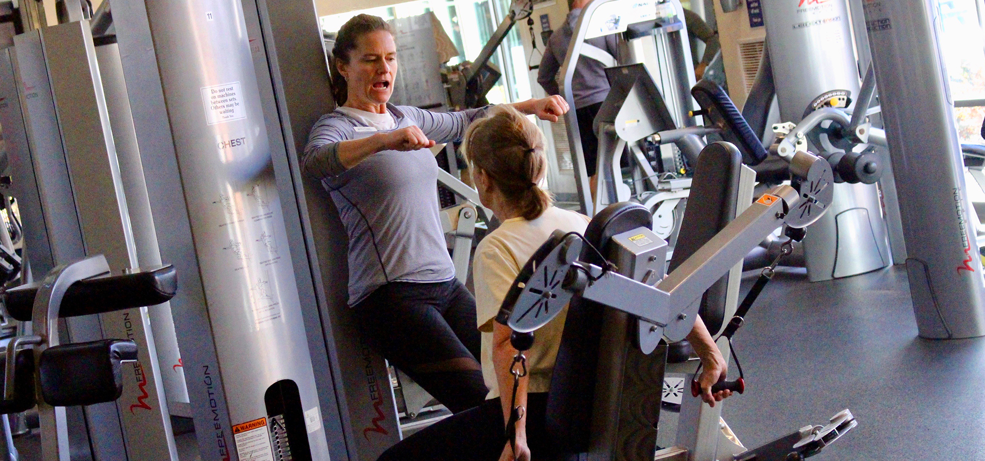A personal trainer working with someone in the fitness center.