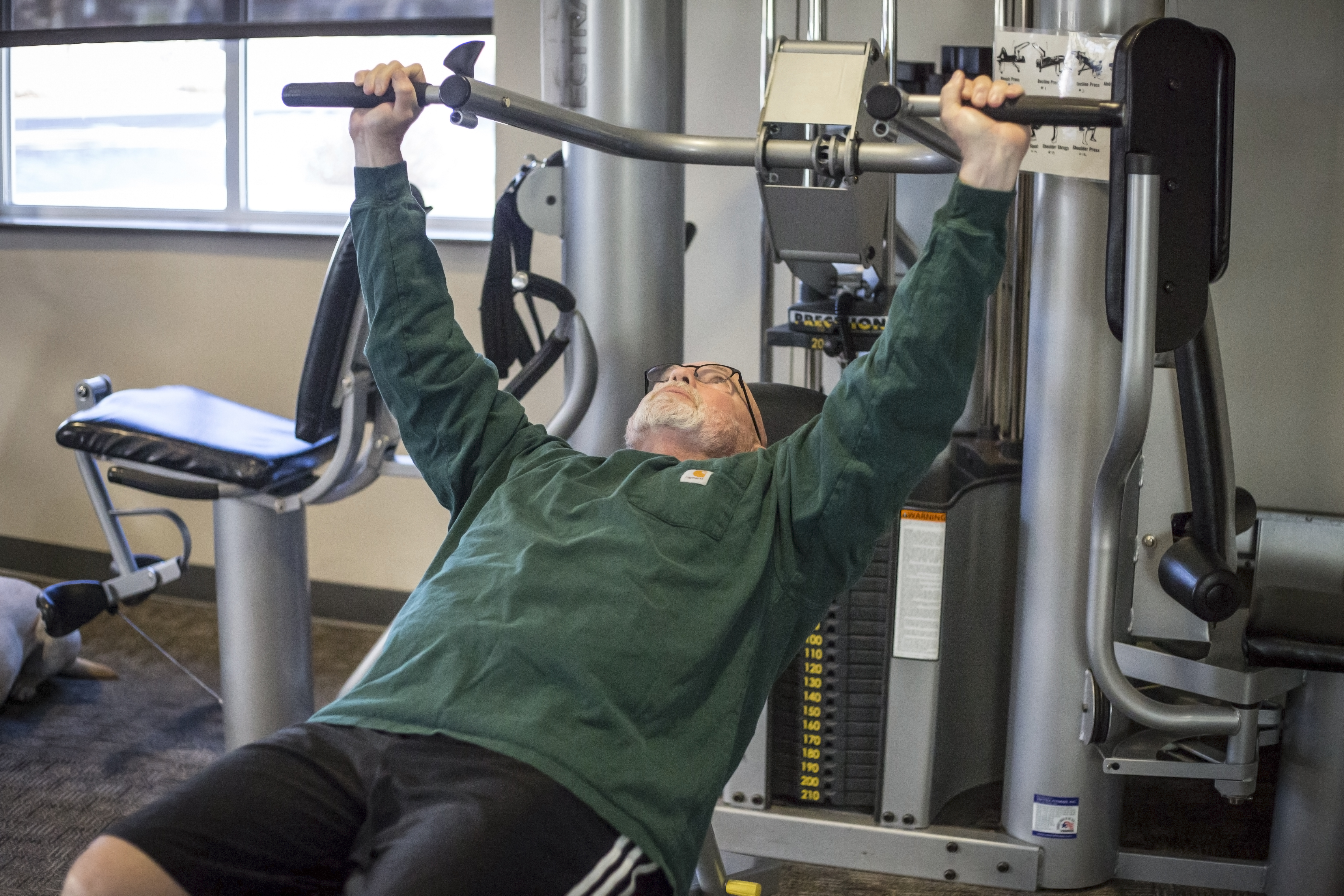Older man operates a weight machine at the Social activity at Bend Senior Center.