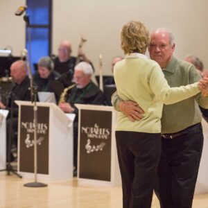 Photo of a couple dancing infront of a band at the St. Patrick's Day Dance