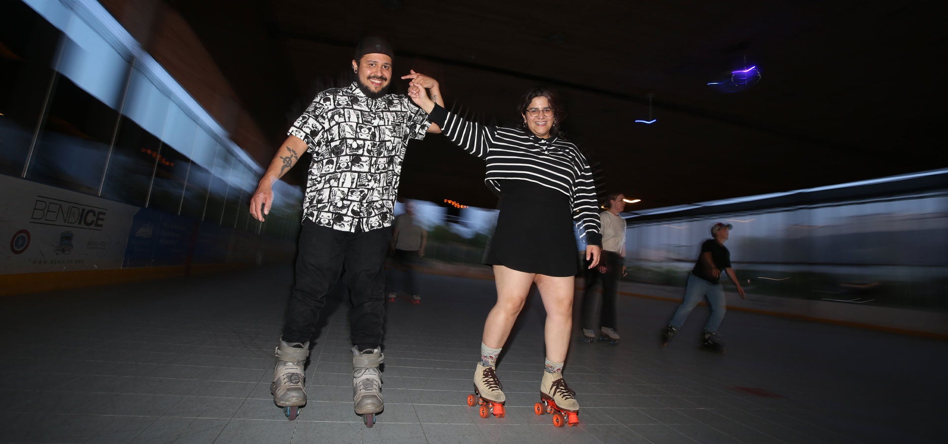 A couple holds hands while smiling during Adult Saturdaynight Roller Jam.