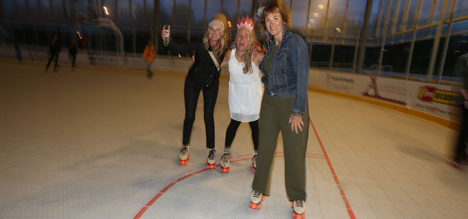 A group of three women enjoying Saturday night roller skating at the Pavilion.