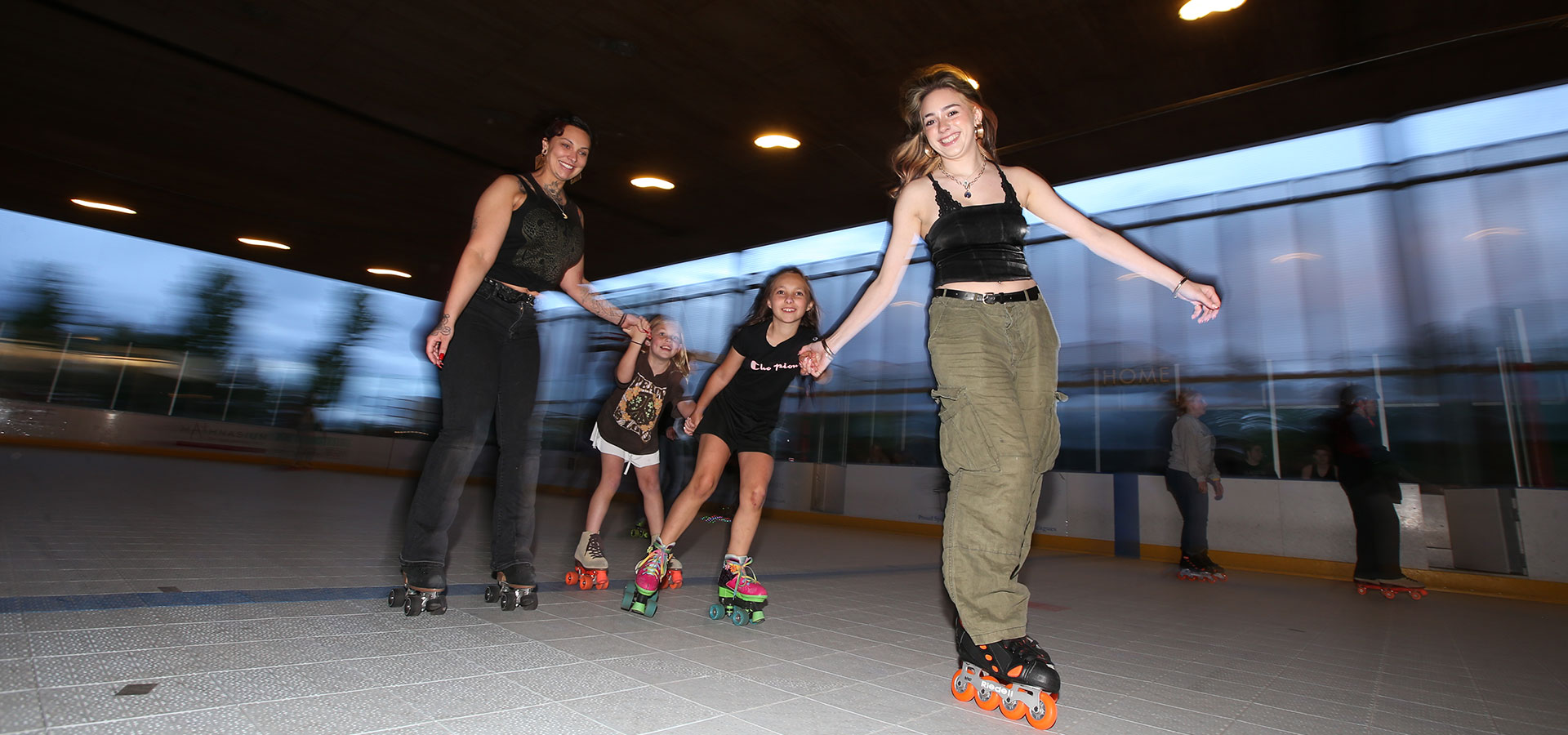 Photo of four patrons holding hands while enjoying Friday Night skate at the Pavilion.