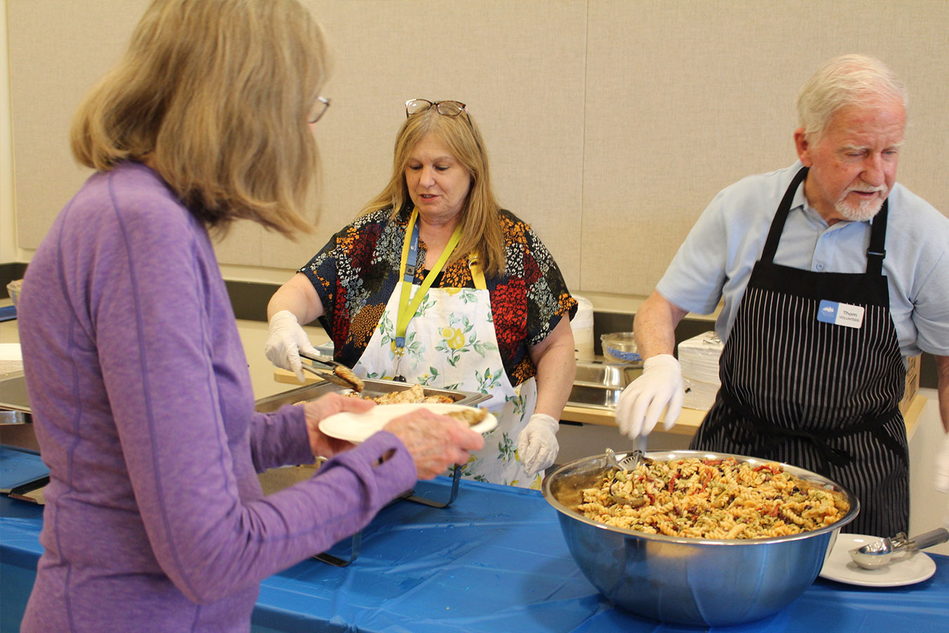 Two volunteers are preparing food for patrons at the Health fair.