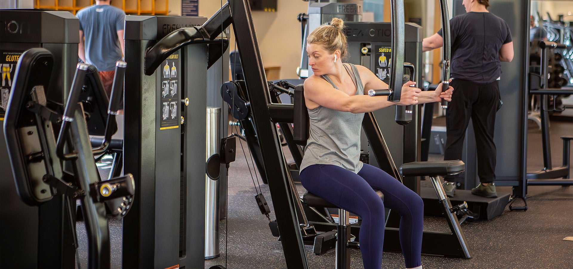 A woman uses a weight machine at Juniper Swim & Fitness Center