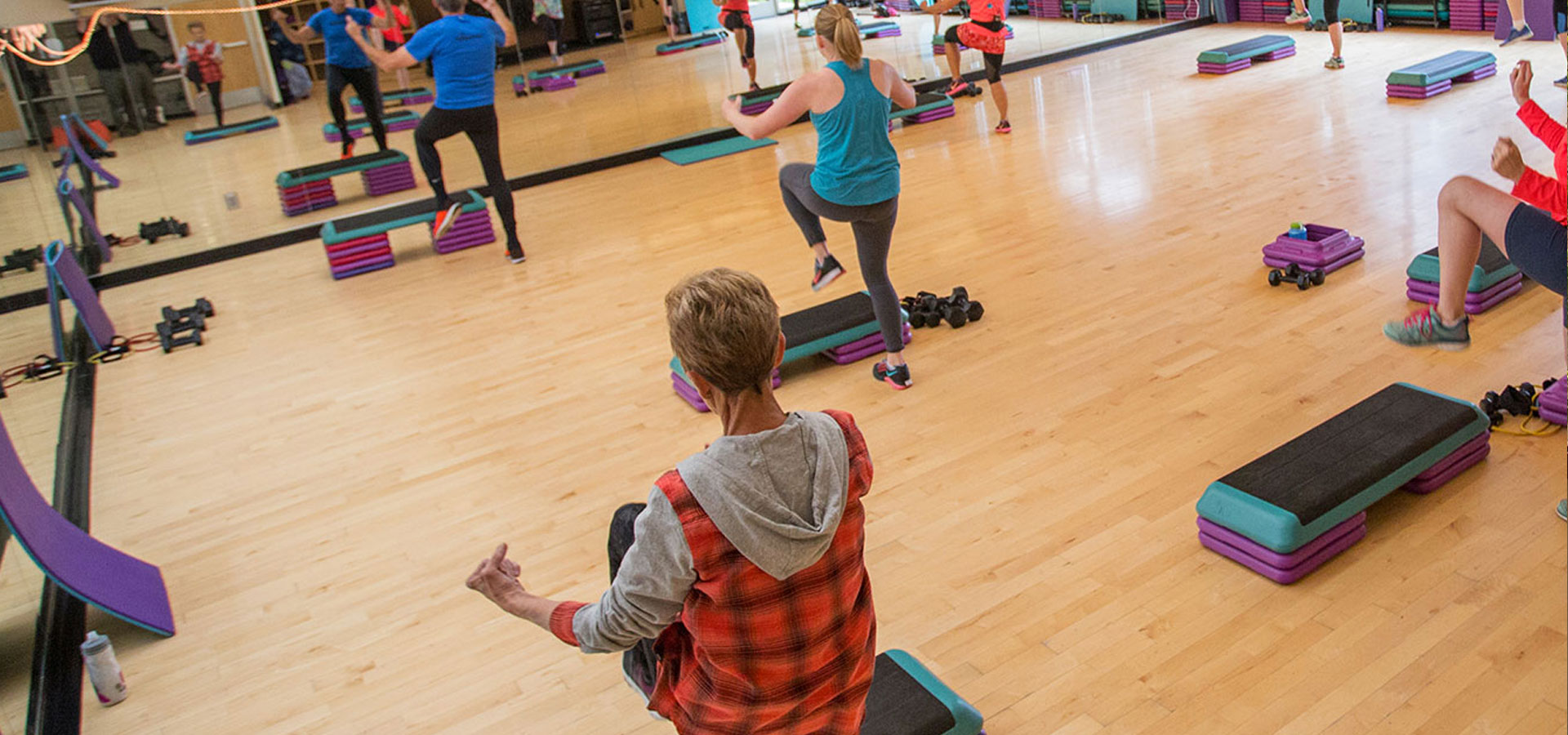 Several patrons are moving in a fitness class.