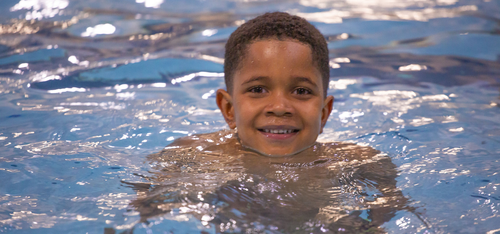 Child smiling while floating in a Juniper pool