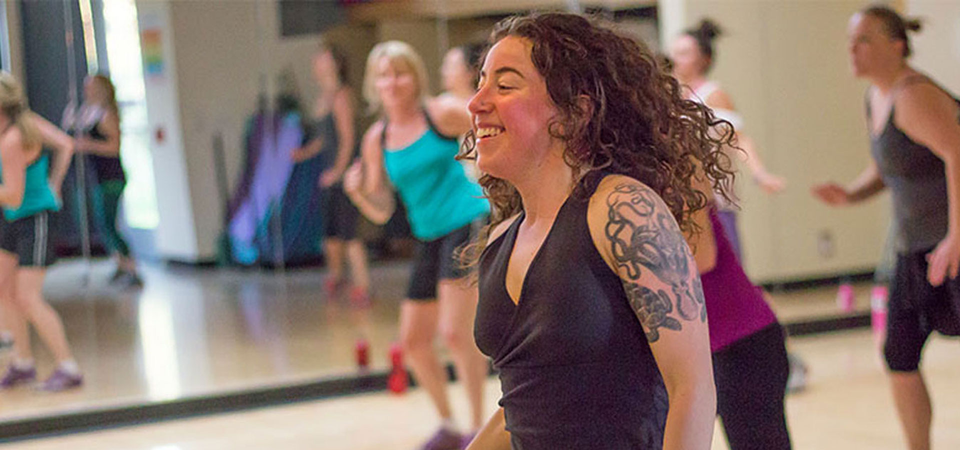 A woman leads a dancing fitness class.
