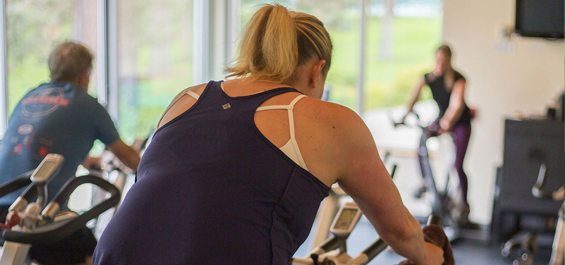 A biking fitness classfeaturing a woman in a workout.