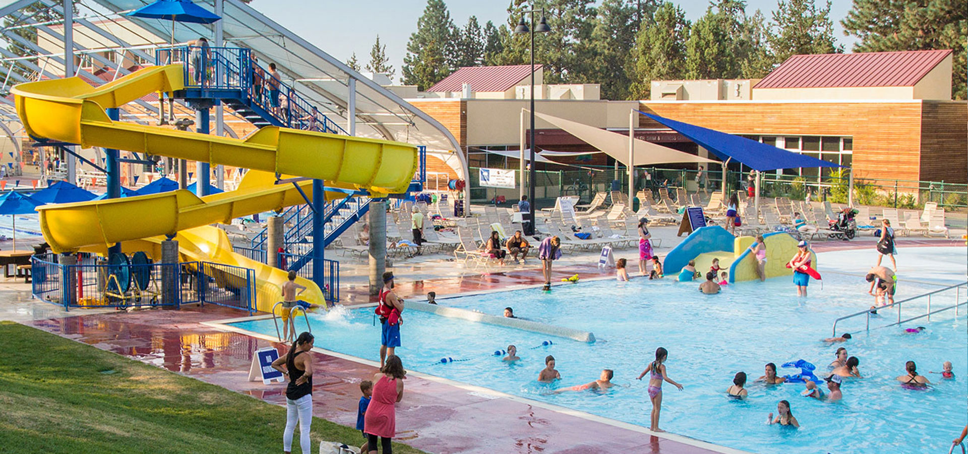 Wide shot of the water slide and activity pool on a sunny day.