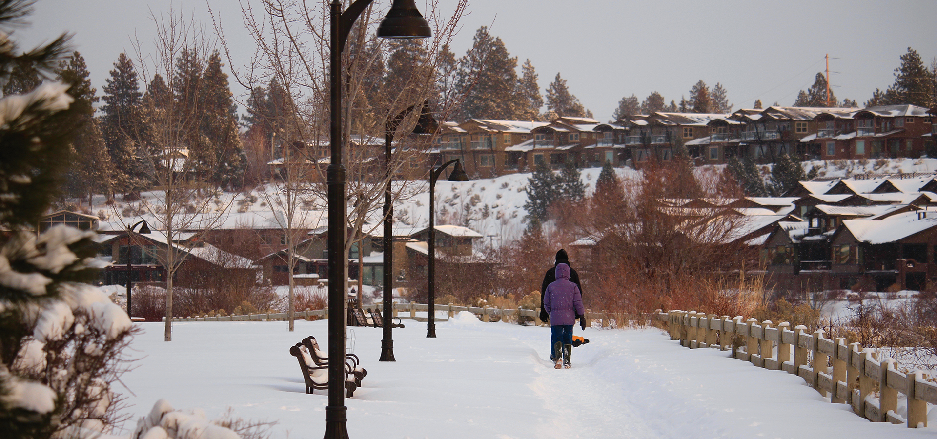 Two people walking in the snow at Riverbend Park.