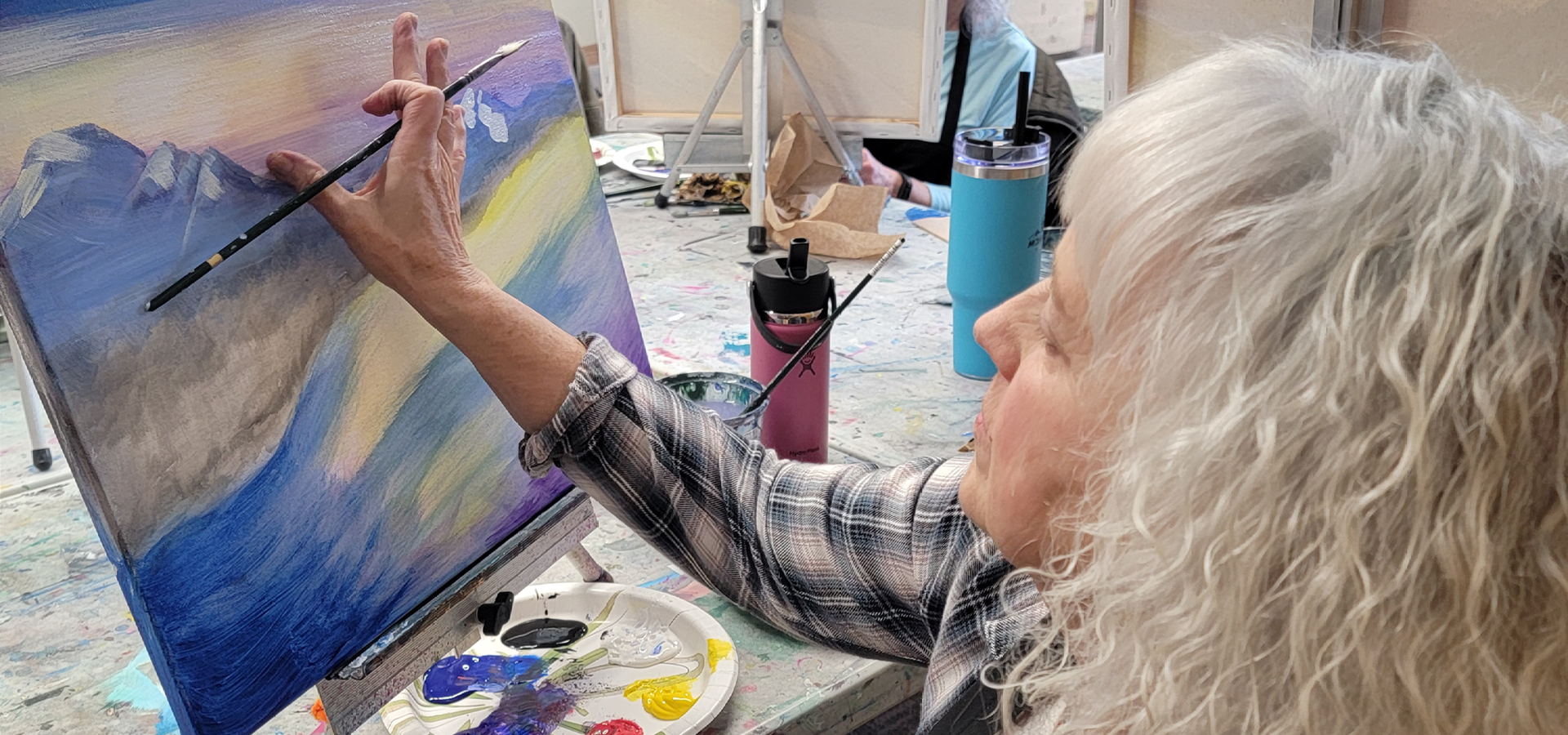 Close-up of a woman painting an alpenglow mountain artpiece