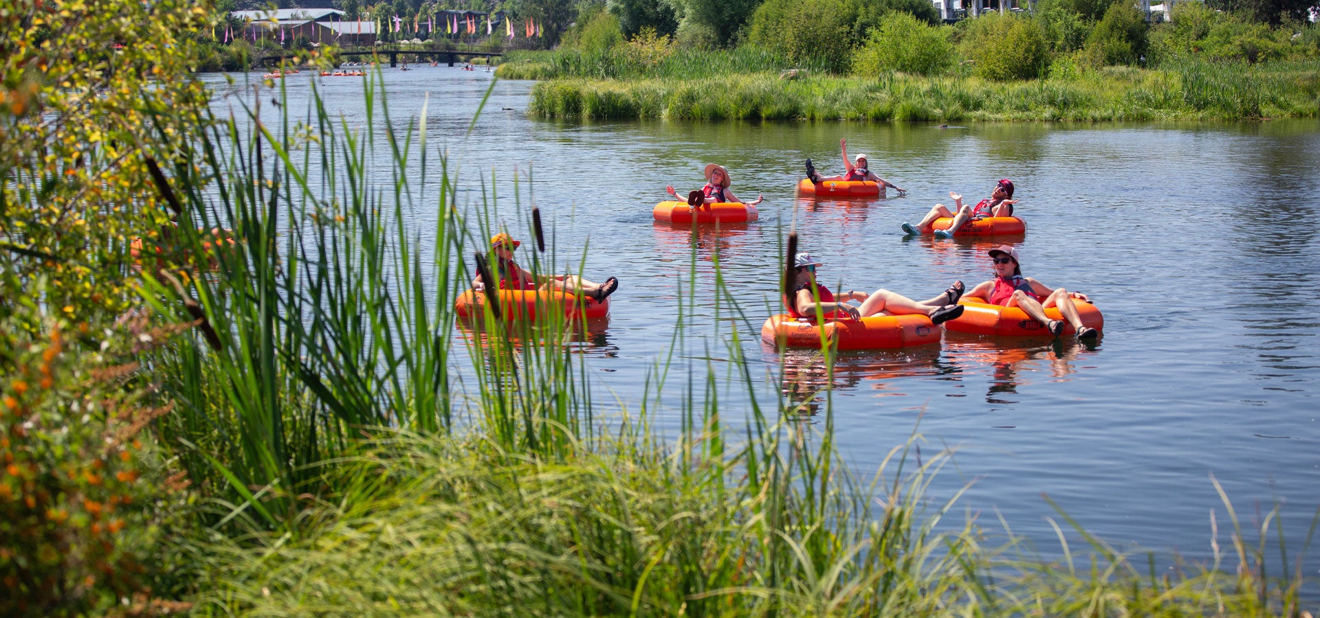 Photo of a group of river floaters with life jakcets and water shoes in their tubes.