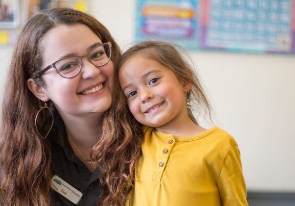 A childcare provider and young girl posing for a photo.