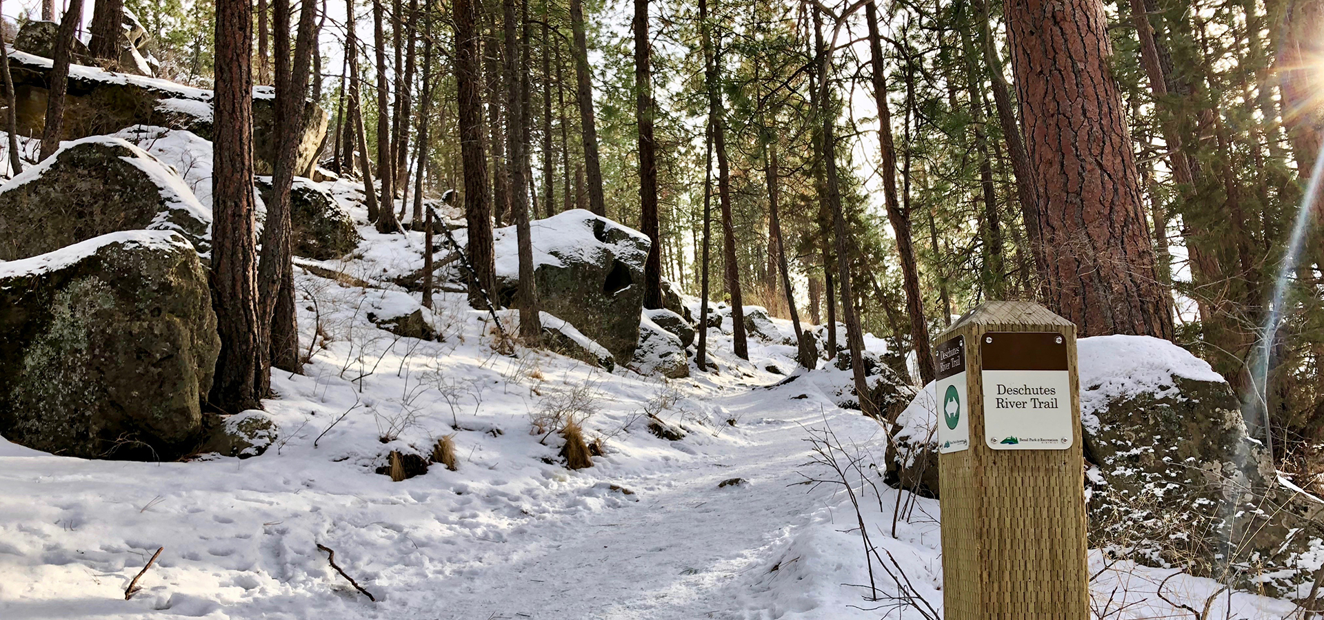 A snowy Deschutes River Trail and sign.