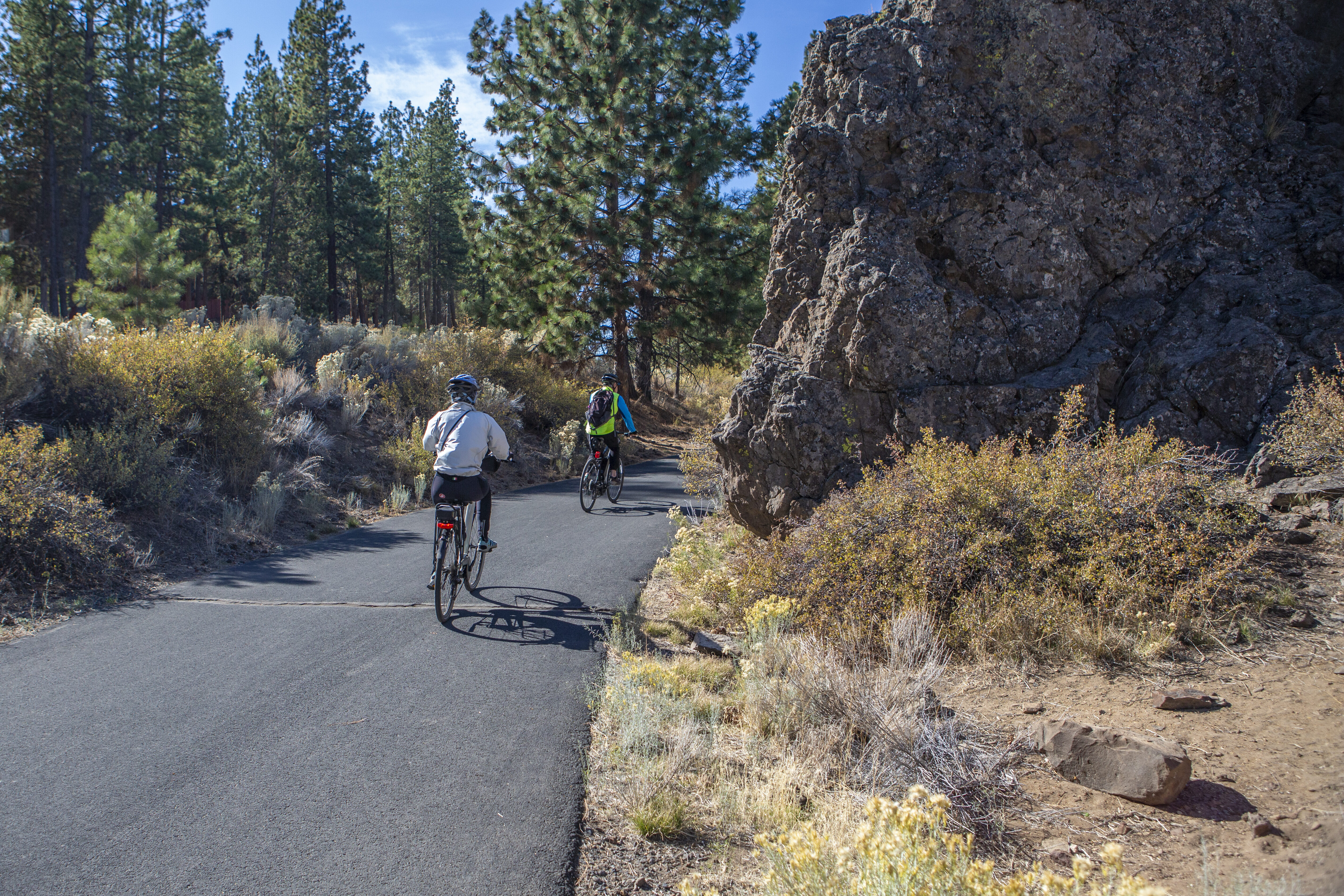 Bikers ride of a paved portion of the West Bend trail