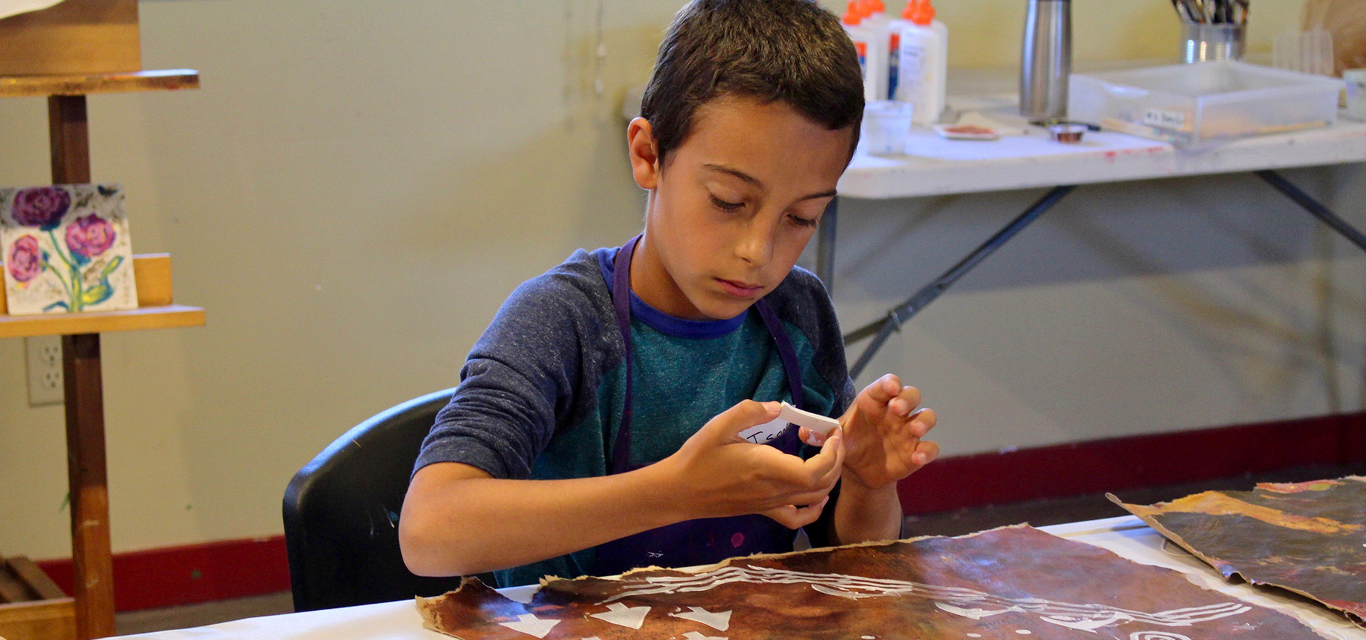 A young boy at an art class.