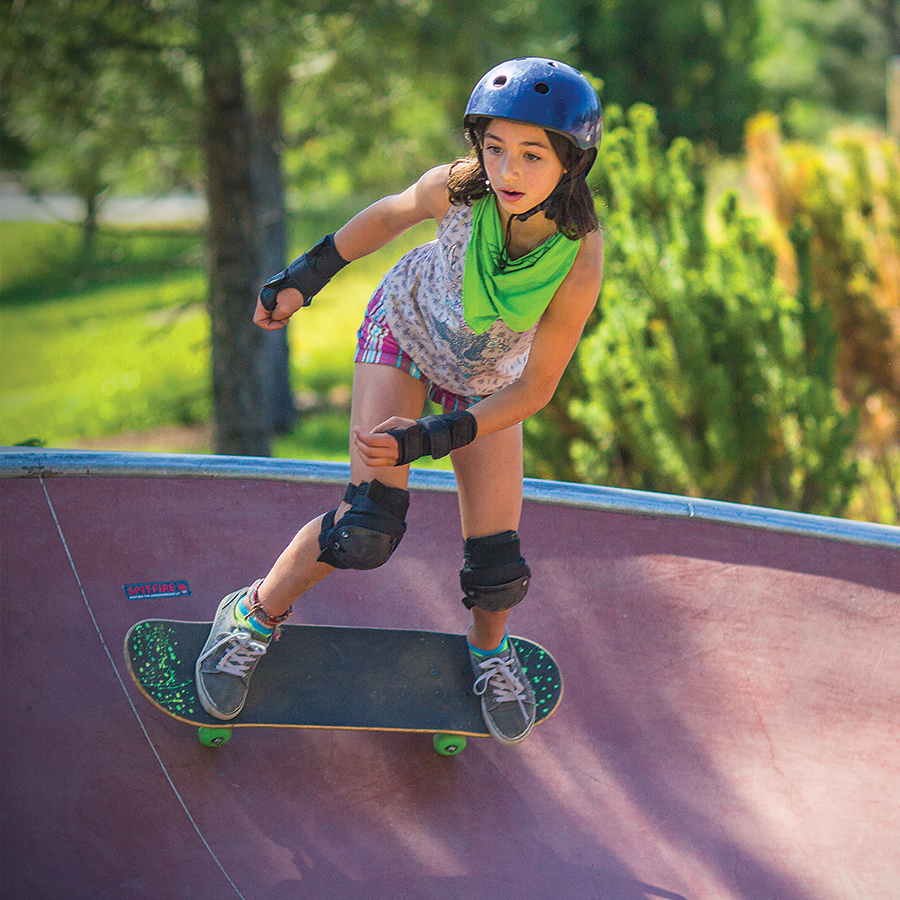 A girl skateboarding at a skate park.