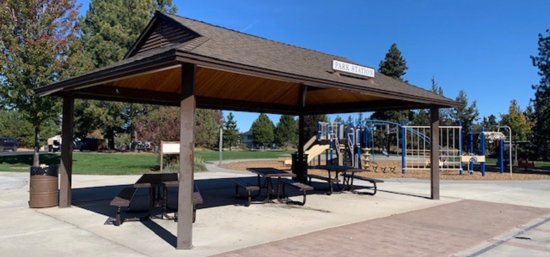 the picnic shelter at Kiwanis park in the sunlight, playground in the background