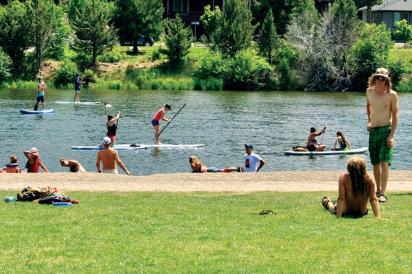people floating and paddleboarding on the Deschutes River in Bend, Oregon.