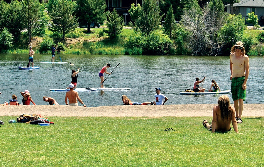 people floating and paddleboarding on the Deschutes River in Bend, Oregon.