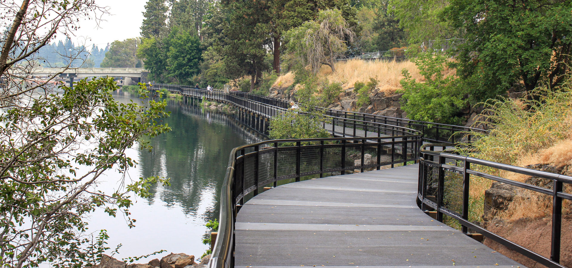Drake park boardwalk along the Deschutes river with Newport Ave bridge in the distance