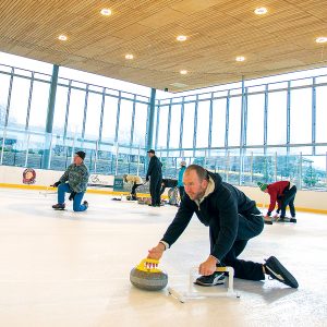 An Adult Curling League participant throwing a stone.