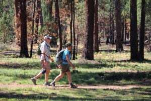 A couple walking on a soft-surface trail through Shevlin Park.