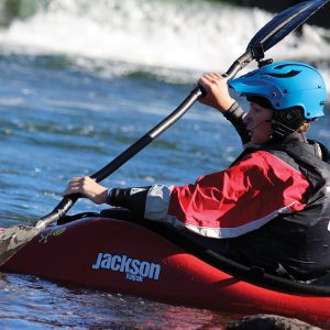 A kid in a whitewater kayak in the Bend Whitewater Park.