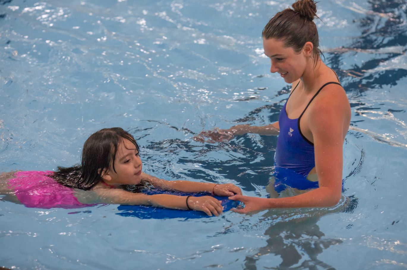 Image of a kid and youth instructor at a Kid's Swim Lessons class.