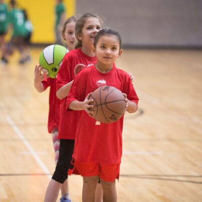 young girls lining up to shoot a basketball