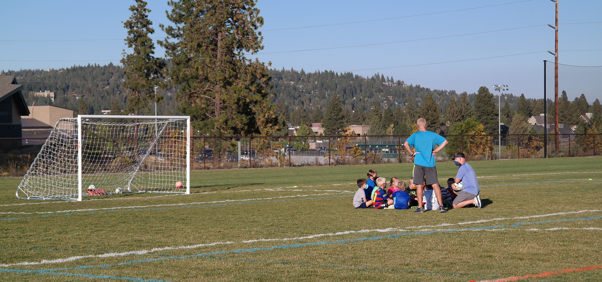 a soccer coach talking to players on a soccer field