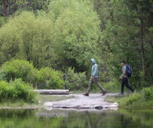 Hikers crossing Tumalo Creek in Shevlin Park