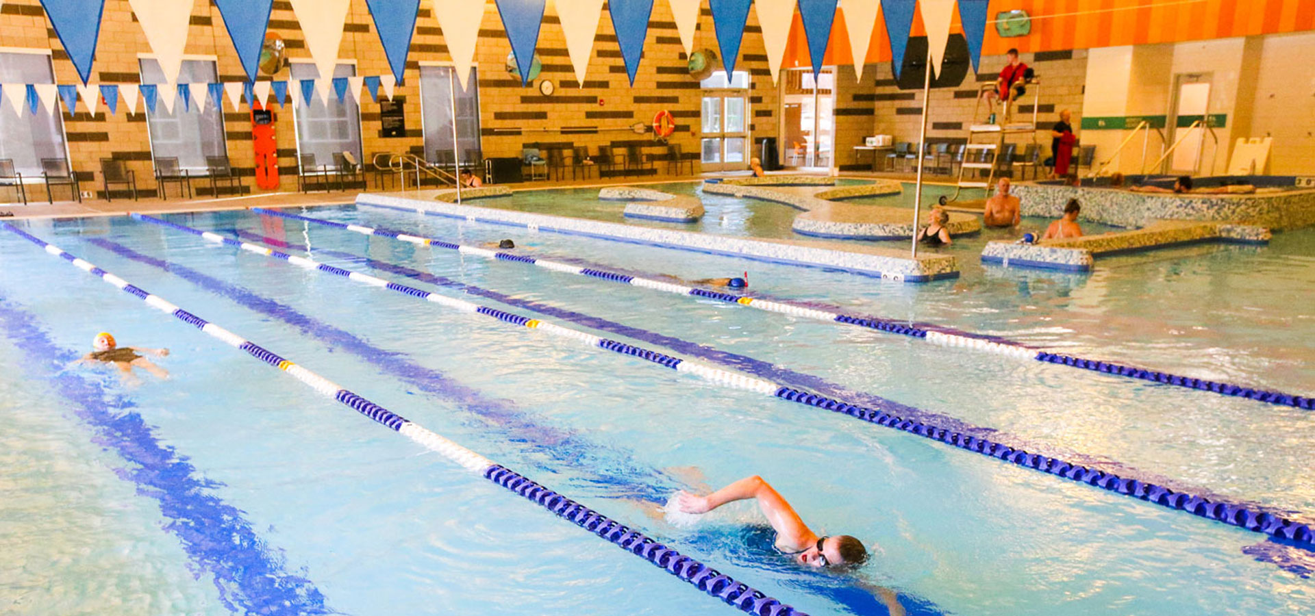 Photo of Larkspur's pools with several lap swimmers and the current in the background