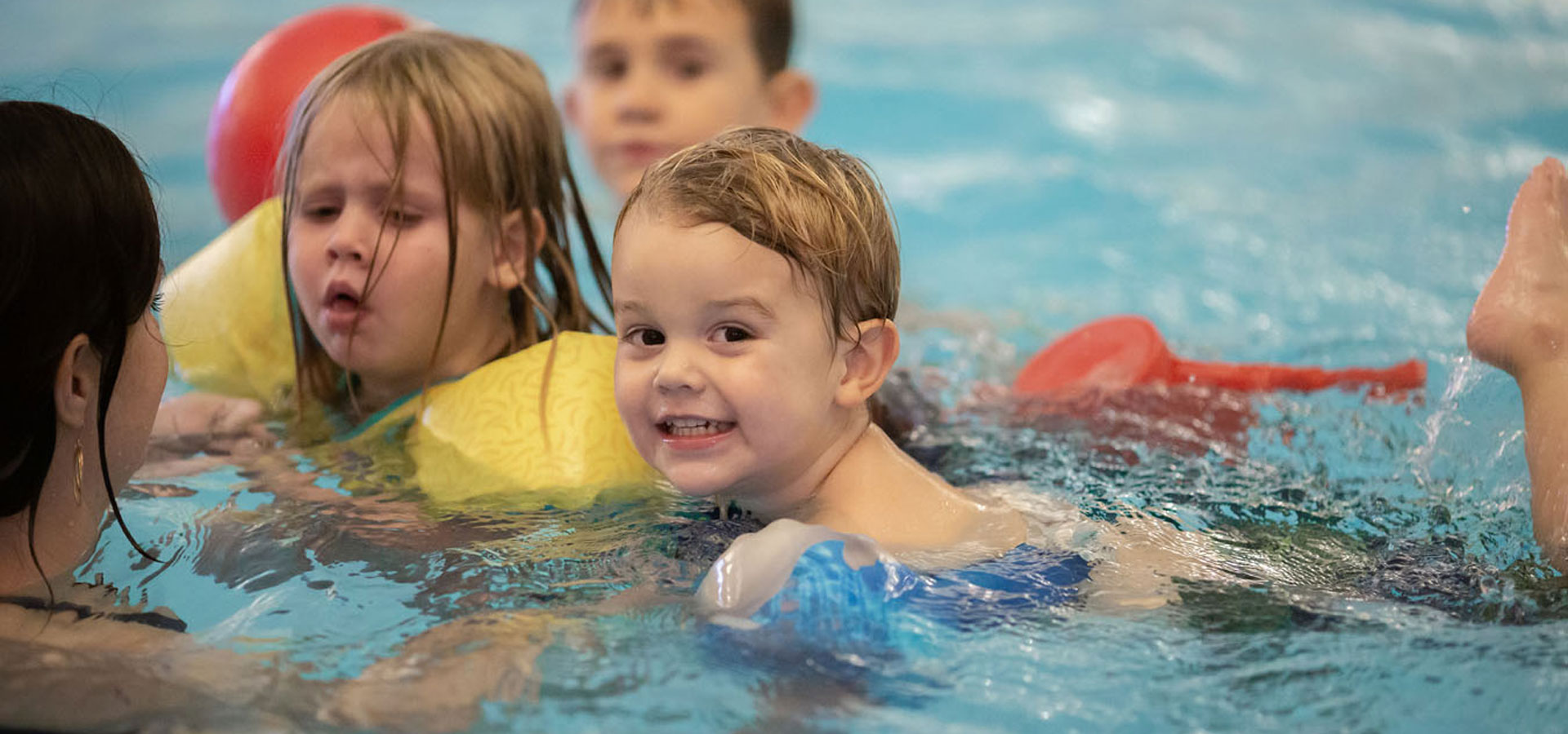 Three young children practice swimming at Larkspur.