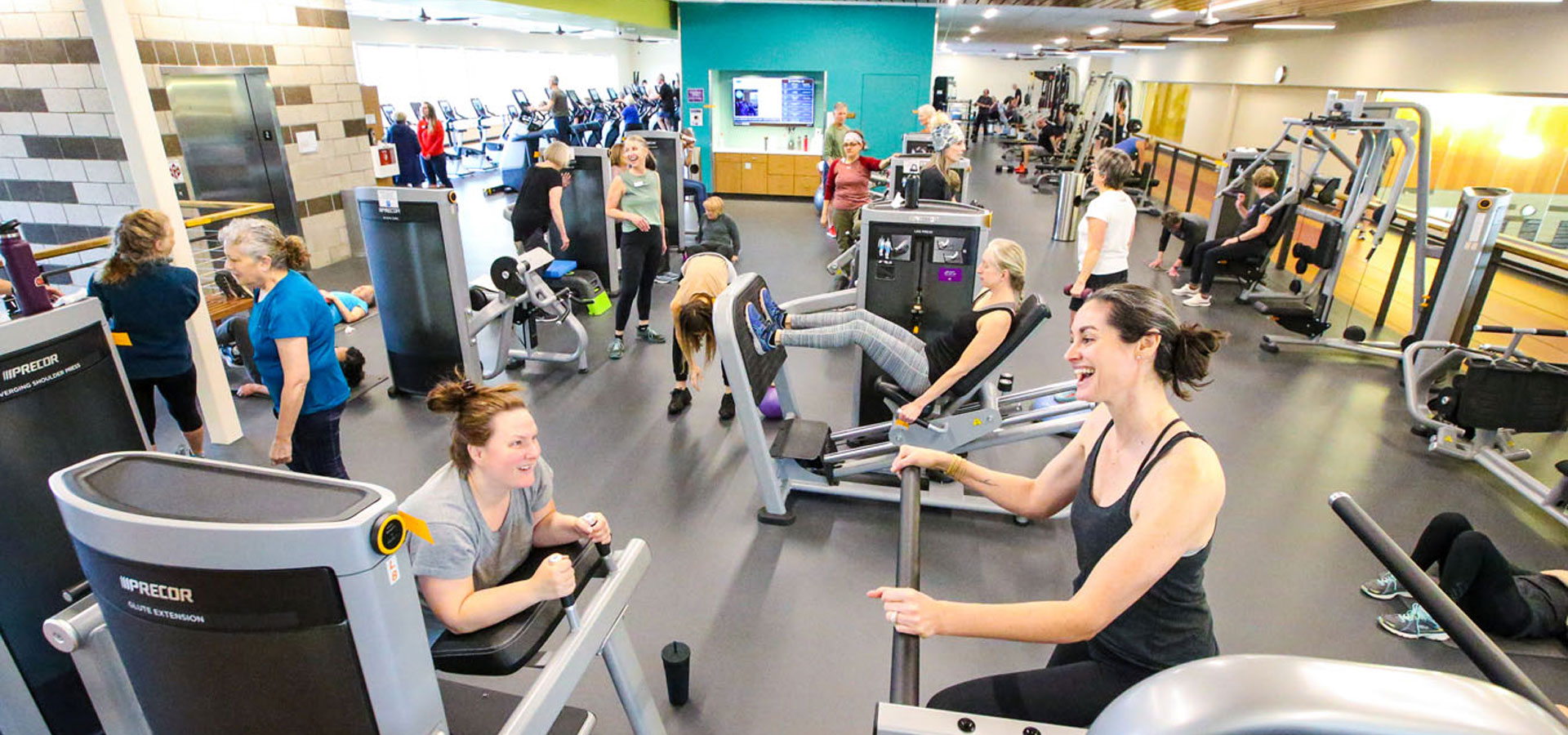 A busy fitness center being used by many patrons.